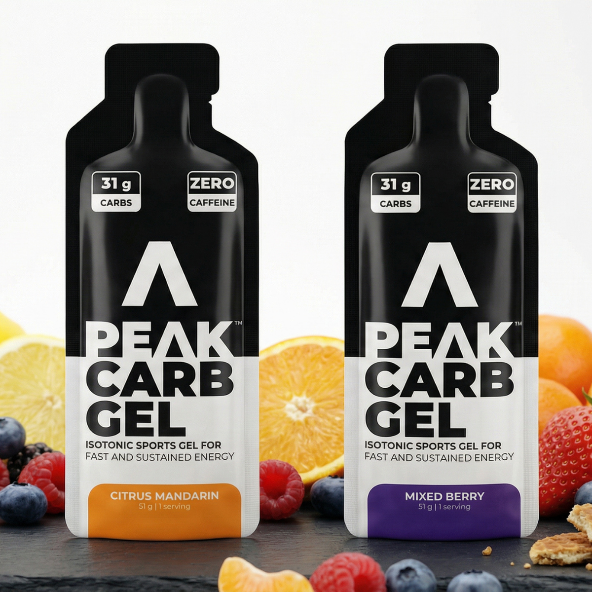 Two Peak Carb Gel packages with fruit and snacks in the background