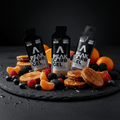 Peak Carb Gel bottles with cookies and fruits on a dark surface
