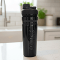Black shaker bottle with a kitchen counter and blurred background